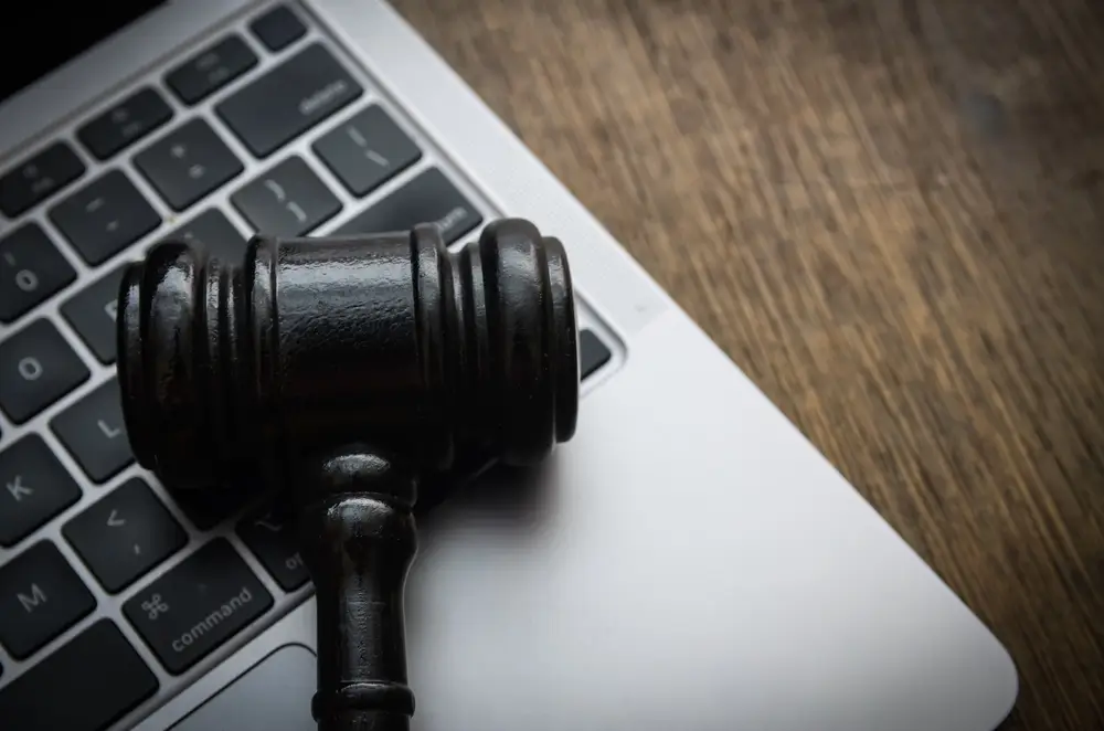Drewniany młotek sędziowski na klawiaturze laptopa - nakaz zapłaty z e-Sądu