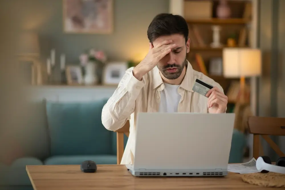 Zaniepokojony klient banku przy laptopie - odrzucona reklamacja kradzieży pieniędzy z konta